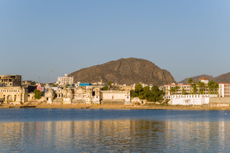Pushkar, India - March 17, 2022: Pushkar Lake is visible in the foreground with several ghats,...