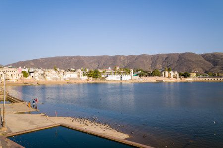Pushkar, India - March 17, 2022: Pushkar Lake is visible with several ghats, historic buildings, and...