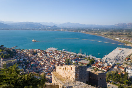 Nauplie, Greece - October 18, 2022: The city of Nauplie, its port, and the Bourtzi fortress on an islet are visible from an elevated viewpoint at the castle, with the sea, marina, and distant mountains in the background.のeditorial素材