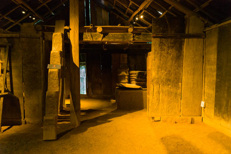 Hanoi, Vietnam - September 15, 2022: The interior of a traditional Hmong house is shown with large wooden pillars, wooden plank walls, a dirt floor, and visible roof beams at the Museum of Ethnology.のeditorial素材