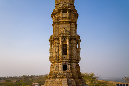 Chittorgarh, India - March 21, 2022: The middle portion of the Kirti Stambh, also known as the Tower of Fame, is shown with intricate stone carvings and sculpted architectural elements under a clear blue sky.のeditorial素材