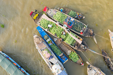 Cai Rang, Vietnam - January 19, 2020: Aerial view of several wooden boats clustered on the river, with vendors selling large quantities of watermelons and other goods at the Cai Rang floating market.のeditorial素材