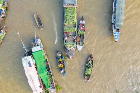 Cai Rang, Vietnam - January 19, 2020: Aerial view of multiple wooden boats clustered on the river, with vendors selling large quantities of watermelons and other goods at the Cai Rang floating market.のeditorial素材