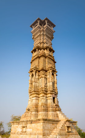 Chittorgarh, India - March 21, 2022: The Kirti Stambh, also known as the Tower of Fame, is shown with detailed stone carvings and sculpted architectural elements under a clear blue sky.のeditorial素材