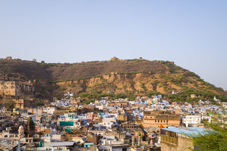Bundi, India - March 20, 2022: The image shows a panoramic view of Bundi city with densely packed buildings in the foreground, Garh Palace on the left, and hillside fort walls running along the ridge under clear daylight.のeditorial素材