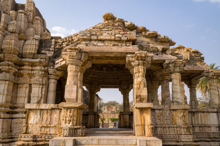 Chittorgarh, India - March 21, 2022: The image shows the entrance and facade of the Samadhisvara Mahadev Temple, featuring intricately carved stone pillars, sculpted reliefs, and weathered stone architecture under a clear sky.のeditorial素材
