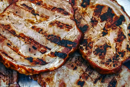 Fried ham slices on grill and exposed for consumptionの写真素材