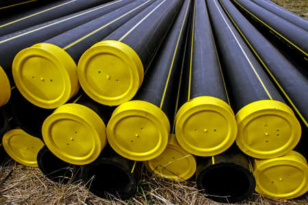 Black plastic pipes with yellow caps and stored for assemblyの写真素材