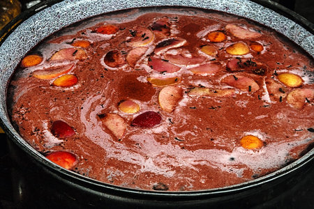Red wine mulled in a large bowl, with spices and fruit ingredients 