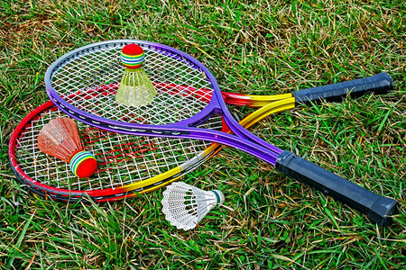 Badminton rackets and shuttlecocks placed on the grass の写真素材
