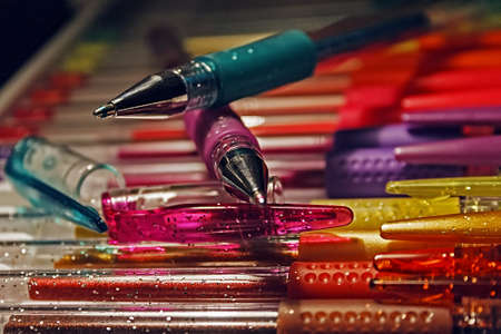 Overlapping colored pens and other pens arranged over a substrate の写真素材