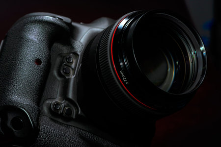 Professional Digital DSLR photo camera on a burgundy 