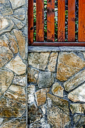 Fence plated with ornamental stone and planks.の写真素材