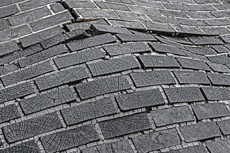 Paving from wooden square, bloated and damaged.