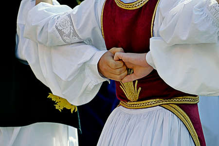 Dancers in traditional costumes who perform the movements of a serbian dance. Detail.の写真素材
