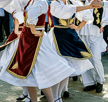 Dancers in traditional costumes who perform the movements of a serbian dance.の写真素材