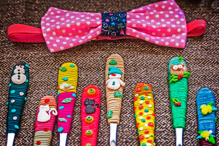 Bowtie and cheerfully decorated spoons for children, in various designs.の写真素材
