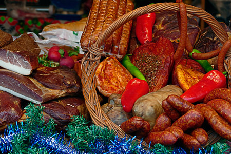 Various smoked sausages specialties, placed on a table and in one wicker basket. Exposed on sale. Specific for December.の写真素材