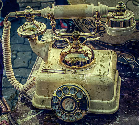 Old telephone sitting on a table with old things. Image digitally manipulated in the form of old photos.の写真素材