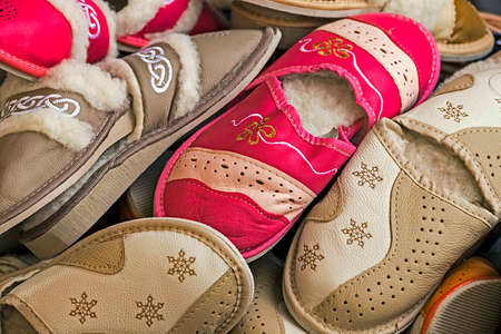 Bunch of furry slippers, red and brown, exposed for sale.の写真素材