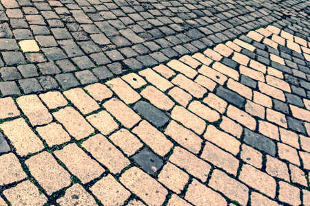 Vintage look at cobblestone sidewalk made of old cubic stones.の写真素材
