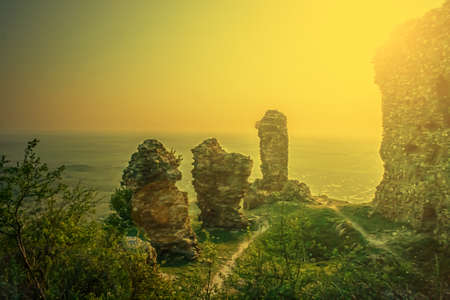Old photo with ruins fortress Siria located in district Arad, Romania. Image digitally manipulated in the form of old photos. Sunset light.の写真素材