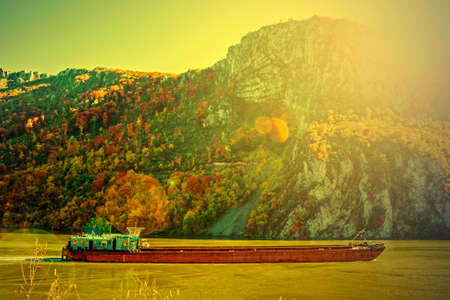 Barge on the Danube sunset with autumn mountain scenery in the background. Romanian Danube Gorges.の写真素材