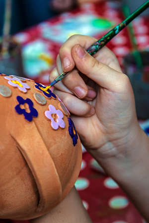 Children painting pottery at a workshop organized by the International Children's Day in Timisoara Romania.の写真素材
