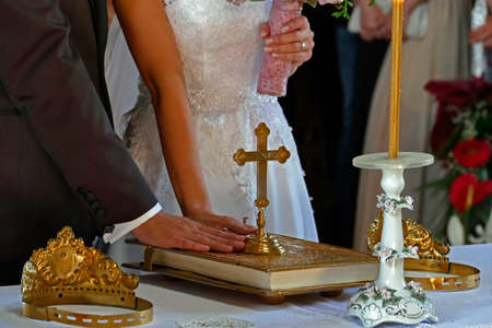 Groom and bride swear with hand on bible faith in marriage in a church.の写真素材