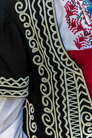 Detail of Bulgarian folk costume for women with multicolored embroidery.