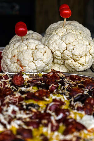 Cauliflower decorated with tomato and traditional Romanian polenta with sausages.の写真素材