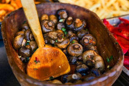 Mushrooms prepared in traditional Romanian mod and placed in a large wooden bowl with wooden spoon.の写真素材