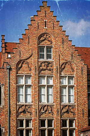Old postcard with architectural facade detail at one old building placed in Bruges, Belgium. Vintage processing.の写真素材