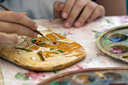 TIMISOARA, ROMANIA - JUNE 01, 2016: Kid who paints a ceramic object. Workshop organized by the City Hall Timisoara with the occasion of the International children Day.のeditorial素材