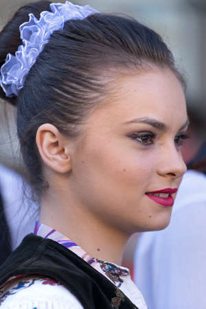 ROMANIA, TIMISOARA - JULY 7, 2016:Young girl from Romania in traditional costume, present at the international folk festival, " International Festival of hearts " organized by the City Hall Timisoara.のeditorial素材