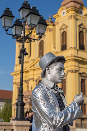 TIMISOARA, ROMANIA - APRIL 31, 2017: Living statue of a man, silver dressed and present on the street inside the CheckART Carnival organized by the City Hall Timisoara. Union Square.のeditorial素材