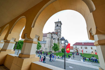 ALBA IULIA, ROMANIA - APRIL 30, 2017: Fish eye view with Saint Michael Roman Catholic Cathedral, from under arcade of orthodox Coronation (Reunification) Cathedral in Alba Iulia city, Transylvania, Romania.のeditorial素材