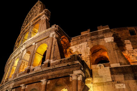 Night view outside the Colosseum, Rome, Italy, with specific ruins and yellow lights.の写真素材
