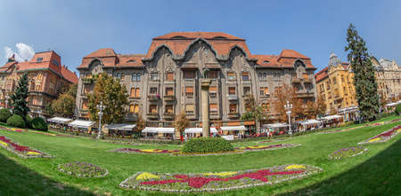 TIMISOARA, ROMANIA - AUGUST 30, 2017: Panoramic view of historic buildings from Victory Square, Timisoara, including wolf statue, with Romulus and Remus kids, symbol of the city.のeditorial素材