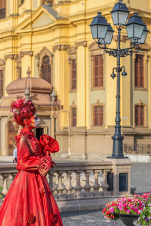 TIMISOARA, ROMANIA - SEPTEMBER 8, 2017: Portrait of living statue of a woman, multicolor dressed and present on the street CheckART Carnival organized by the City Hall Timisoara. Union Square.のeditorial素材