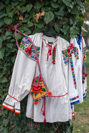 Old traditional Romanian folk costumes with embroidery specific for Bistrita-Nasaud area Romania exposed at one traditional fair.の写真素材