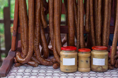Romanian sausages (sausages), smoked and dried, together with jars with natural lard exposed for sale.の写真素材
