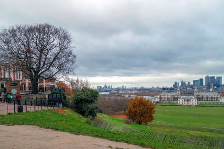 LONDON,ENGLAND - NOVEMBER 29, 2017: Panoramic view with people that visit Royal Greenwich Observatory at Greenwich Hill, skyline of Canary Wharf and Queen's House.のeditorial素材
