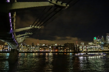 Pictorial view with London skyscrapers in the night, under a bridge. Glass filter applied.の写真素材