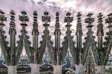 Old photo with view of Milan's financial district in background and statues of Duomo of Milan in front. Lombardy, Italy. vintage processed.の写真素材