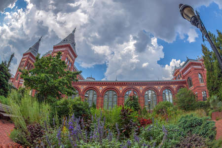 WASHINGTON DC, USA - SEPTEMBER 4, 2018: Victorian facade of the Smithsonian Castle, Arts & Industries Building, with beautiful garden in foreground, located on National Mall.のeditorial素材