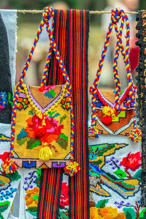 Background with traditional bags, belts and material embroidered, decorated with specific patterns of the Bistrita-Nasaud area, Romania and exposed for sale.の写真素材