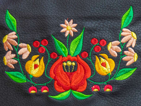 Background with detail of traditional Hungarian folk embroidery handmade on leather suport.の写真素材