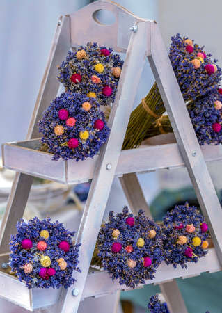 Bouquets of lavender flowers displayed on a decorative wooden support, painted white.の写真素材