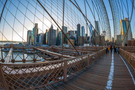 NEW YORK, USA - MARCH 9, 2020: Large angle view of Brooklyn bridge in afternoon light with tourists that crossing.のeditorial素材